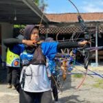 Seorang atlet sedang membidik target dalam olahraga panahan