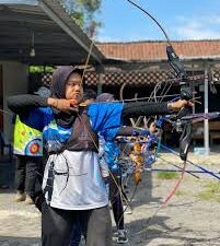 Seorang atlet sedang membidik target dalam olahraga panahan