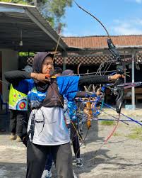 Seorang atlet sedang membidik target dalam olahraga panahan